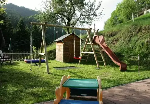 den Garten mit Spielplatz und Liegestühlen zum Sonnenbaden